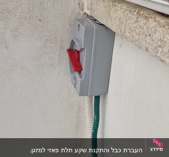 מתג חשמלי עם ידית אדומה על קיר חיצוני